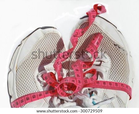 shabby elder training shoes with measuring tape like a gift, a lot of training done. close up isolated