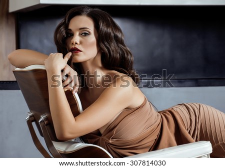 beauty yong brunette woman sitting near fireplace at home, winter warm evening in interior, waiting to celebrate