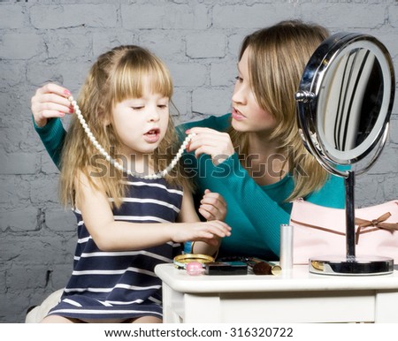young family mother and daughter make up at mirror, learning use cosmetic close up