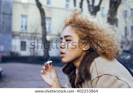 young pretty girl teenage outside smoking cigarette, looking like real junky, social issues concept