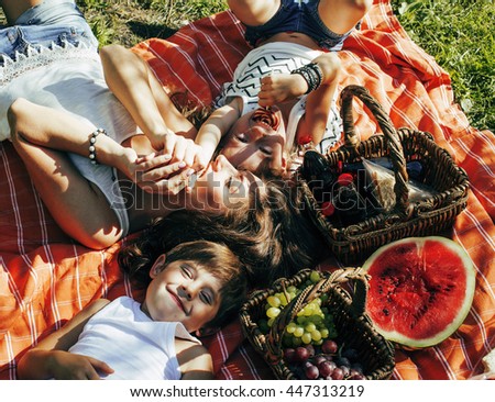 cute happy family on picnic laying on green grass mother and kids, warm summer vacations close up, brother and sister