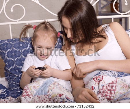 Portrait of mother and daughter siting on sofa hugging and smiling