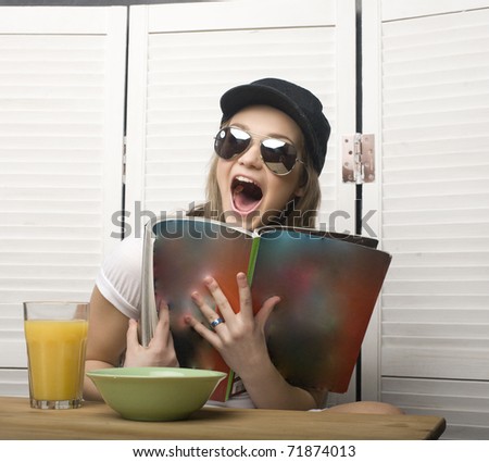 portrait of happy funny teenage girl having breakfast and reading journal
