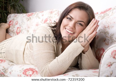portrait of pretty young woman smiling laying on sofa