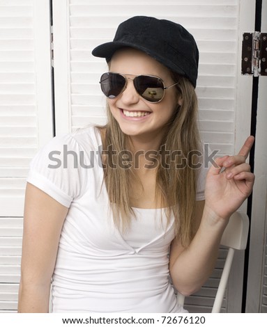 portrait of funny teenage girl in white dress and sunglasses, having breakfast