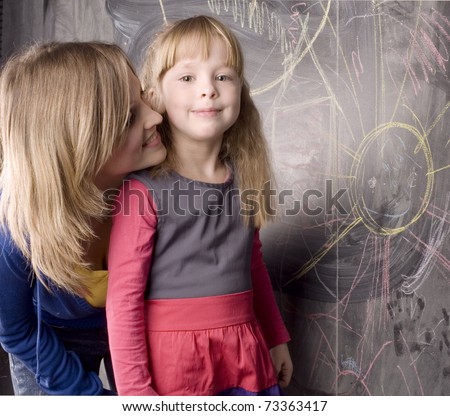 portrait of mother and daughter near blackboard, teaching process