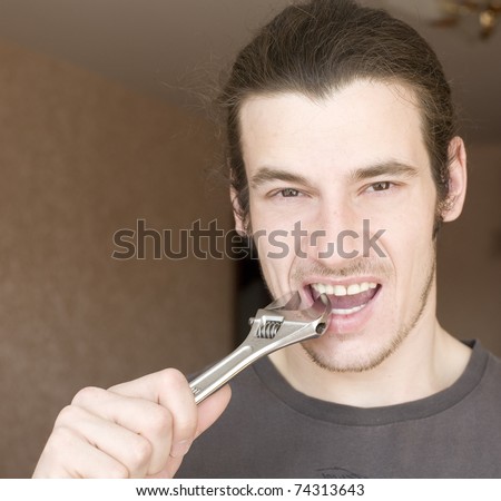 Portrait of young brutal man with wrench