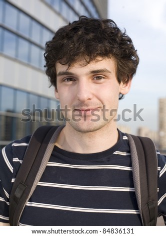 close up portrait of college student stood outside, talking on phone