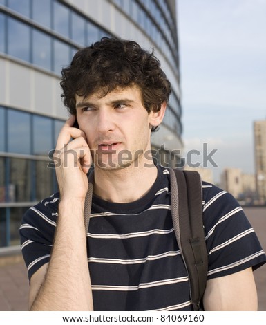 close up portrait of college student stood outside, talking on phone