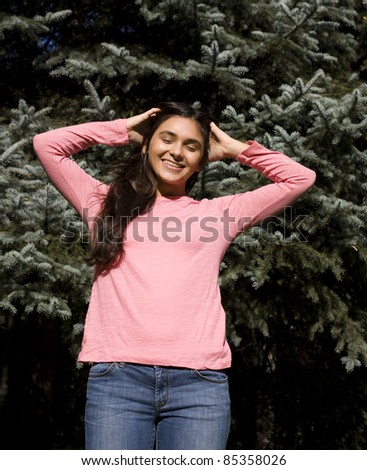 Enjoying the nature. Young woman arms raised enjoying the fresh air in green forest.