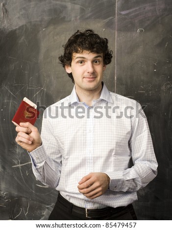 portrait of man student with money and passport, standing at blackboard