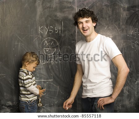 portrait of teacher and little student, father and son near blackboard