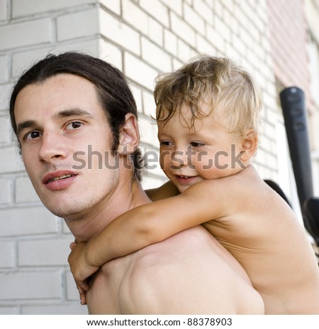portrait of happy father with son hugging outside