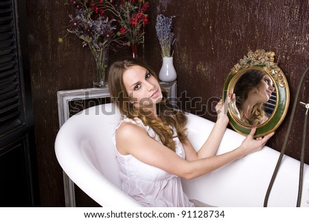 beautiful woman in bathroom antiques holding mirror
