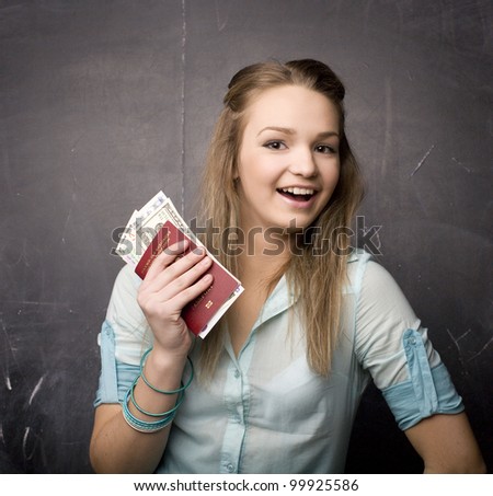 portrait of cute girl student with money and passport