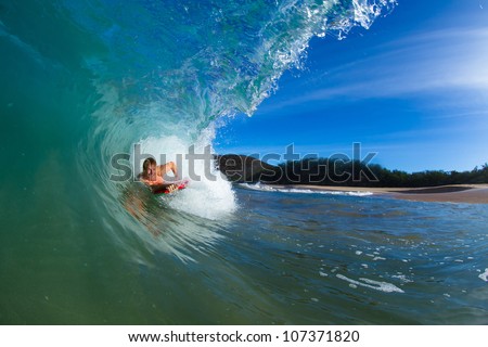 Boogie boarder surfing a wave, riding in the tube or barrel