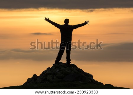 High achiever, silhouette of a man on top of a mountain