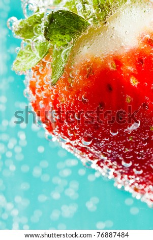 Strawberry cocktail - in soda water - against an electric blue background