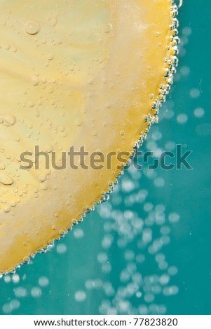 Lemon cocktail - in soda water - against an ultramarine blue background
