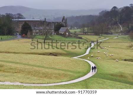 The Dales Way footpath as it winds its way serenely past Bolton Abbey in the Yorkshire Dales towards Windermere in the Lake District - colour with walkers