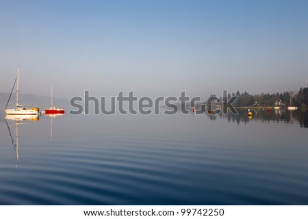 Colourful boats on a foggy Lake Windermere, Lake District