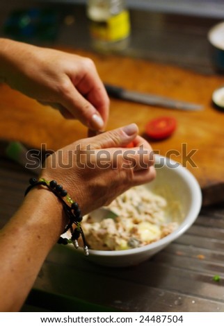 Hands cooking. Blurred background with bowl, counter and knife