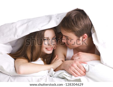 young man and woman in a bed under blanket on white background
