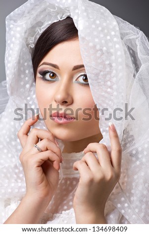 close up portrait of a beautiful brunette girl in wedding veil
