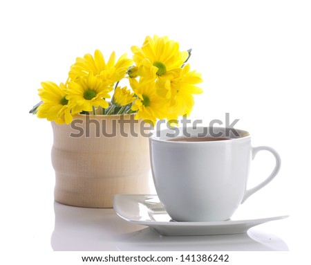 tea and yellow flowers isolated on white