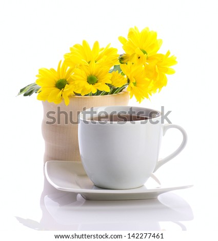 tea in white cup and yellow flowers isolated on white