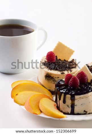 lunch in cafeteria - coffee and beautiful colorful, chocolate dessert with slices fruit and raspberry on white background