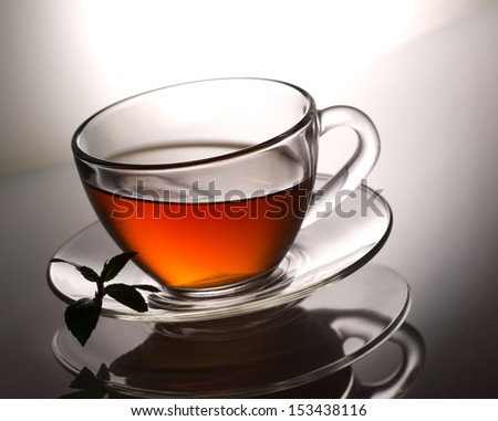 beautiful tea in glass cup and fresh mint on light and grey background, modern style
