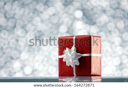 red present box with white bow on bokeh light  background
