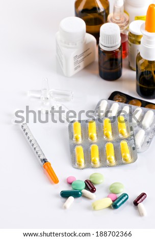 colorful medicament in tablets, capsules, blisters, insulin syringe and different bottles on white background, top view