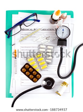 doctor\'s accessories and drugs on medical authorization form on green board on white background, top view