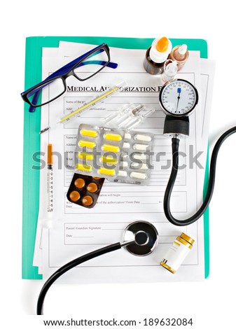 medical accessories and drugs on medical authorization form on green board on white background, top view
