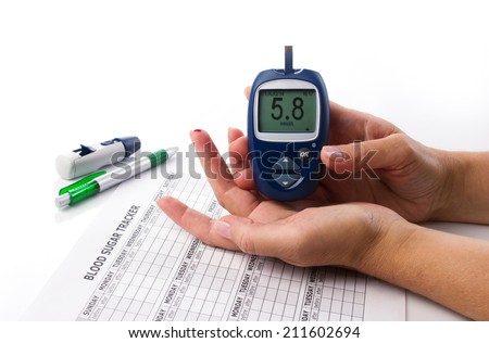 glucometer in woman\'s  hand, display of glucometer showing  number 5.8, on white background with medical form and pen
