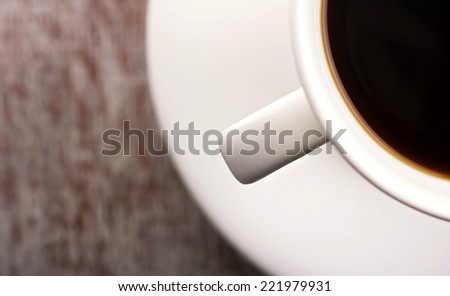 close-up cup  with brown drink and saucer on blurred background with place for your text