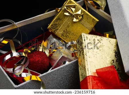 closeup big opened glamour gift box with bright little gift boxes and christmas red ball