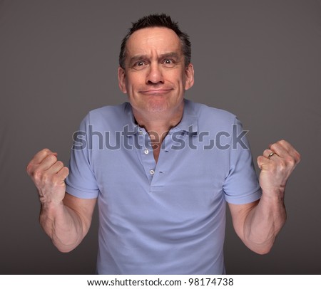 Angry Middle Age Man Pulling Face and Shaking Fists Grey Background