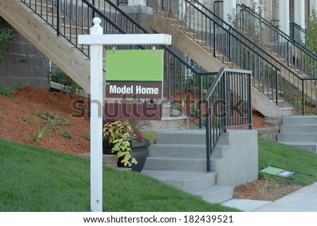 Model home sign out in front of a row of new construction town homes