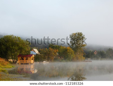 Beautiful misty landscape on the pond with pavilion