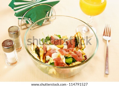 Salad with smoked duck fillet on a glass dish