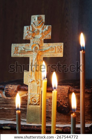Orthodox Christian still life with metal cross and burning candles