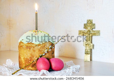 Christian Easter still life with red eggs and burning candle over the cake