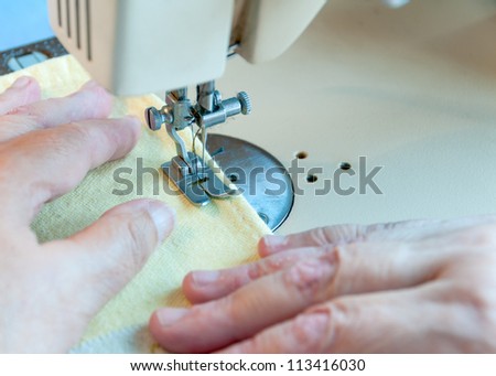 the hand of the old woman\'s guide the fabric for sewing machine