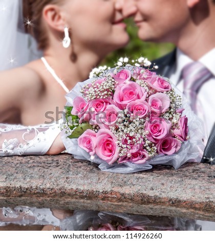bride and groom kiss on the background of a bouquet of flowers