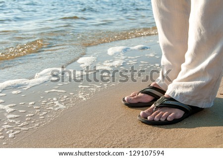 man\'s  legs in an open shine on the sea shore