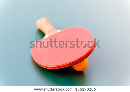 racket for tennis and ball lying on a green table