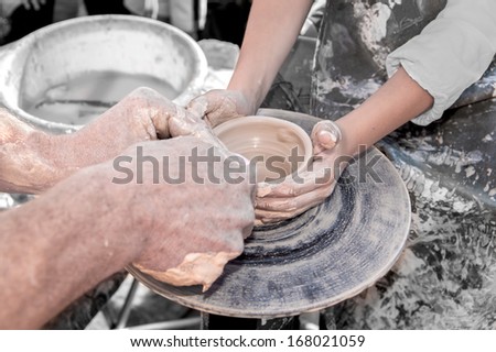hand of the potter and the child in the creation of new products from clay